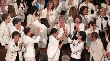 SOTU white suits explained: Group of Democratic women wearing white celebrate and clap