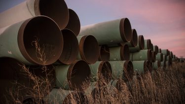 Everything you need to know about pipelines in Canada: Miles of unused pipes in field of grains against sunset
