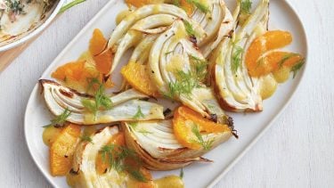 Roasted fennel with orange dressing on white plate