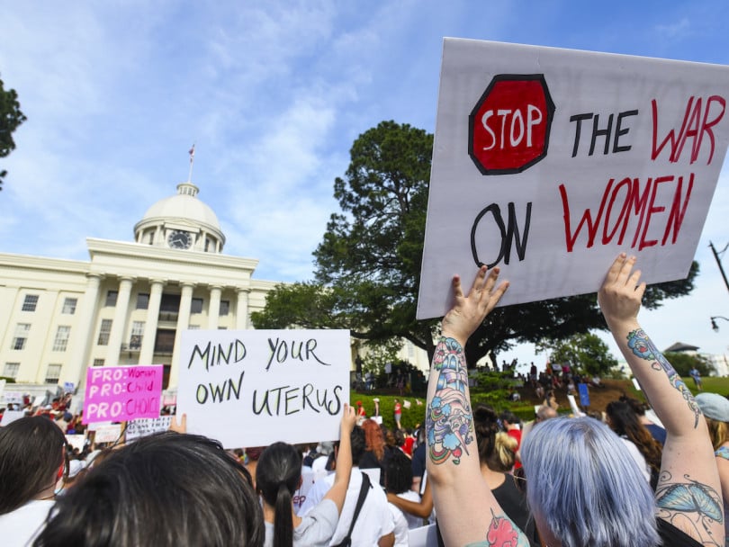 Extreme abortion bans U.S.-women and men march holding signs that have messages supporting pro-choice and putting down attempts to change abortion legistlation