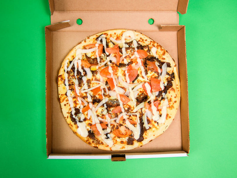 Regional Canadian pizzas: donair pizza pie in box on green background