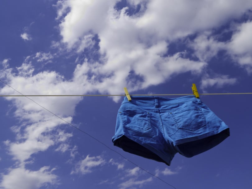 varicose veins spider veins treatment feature image shows blue shorts hanging on a laundry line outside against a blue sky with a few white clouds