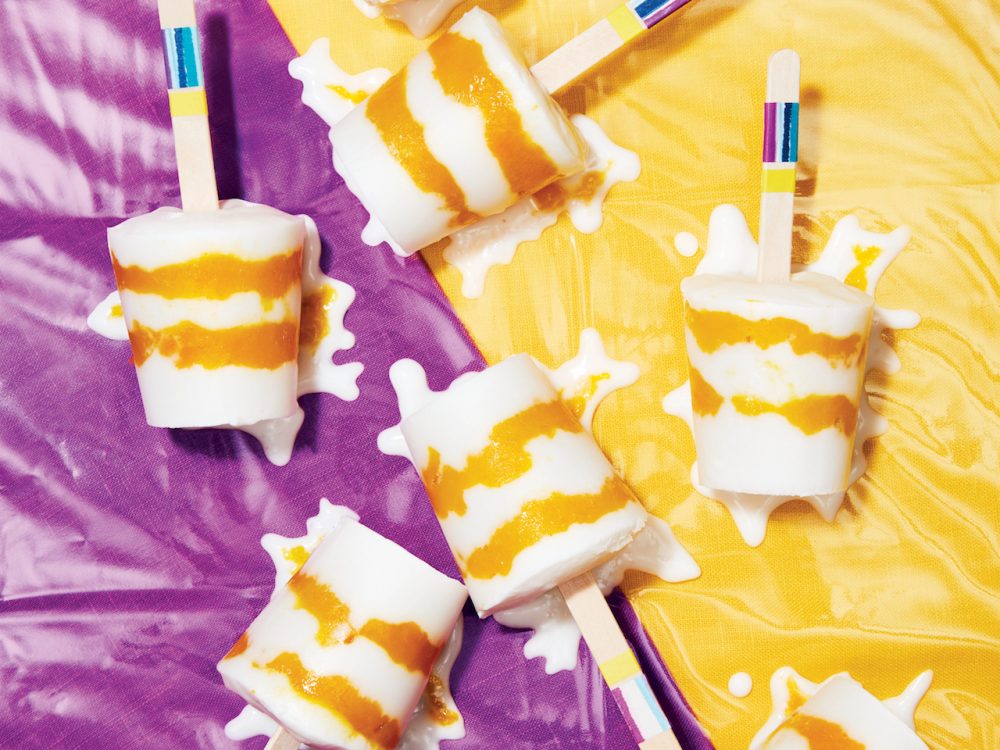 overhead shot of Vegan Mango Coconut Ice Pops on a purple and yellow background