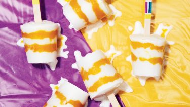 overhead shot of Vegan Mango Coconut Ice Pops on a purple and yellow background