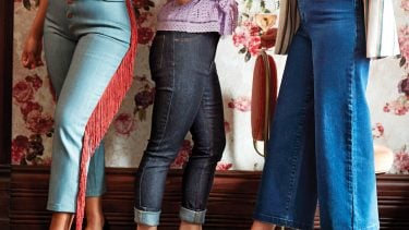 Photo of three women wearing Canadian denim in front of a floral wallpaper background and dark wooden floors.