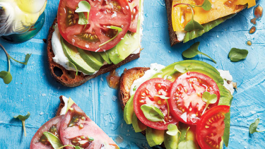 Tomato-topped avocado toast on a blue background, one of the most popular food trends