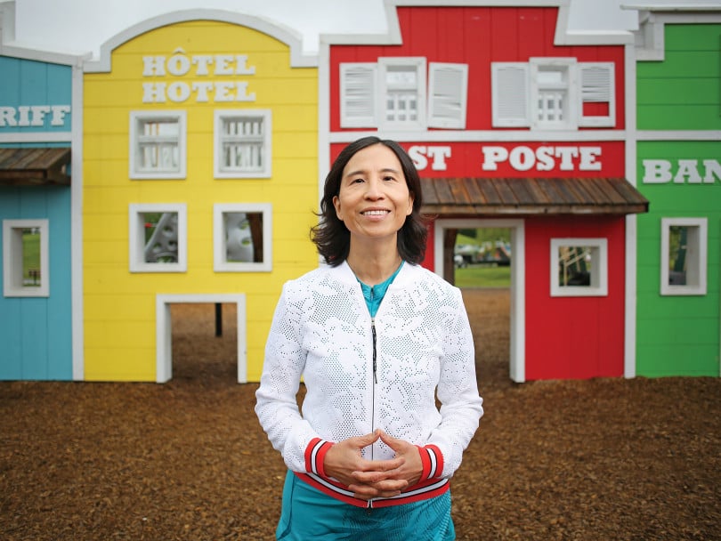 Teresa Tam stands in front of a row of colourful homes.