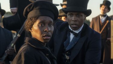 A woman dressed in pre civil-war era hat and cloak