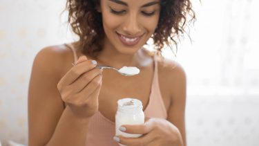 Woman Eating small container of Yogurt