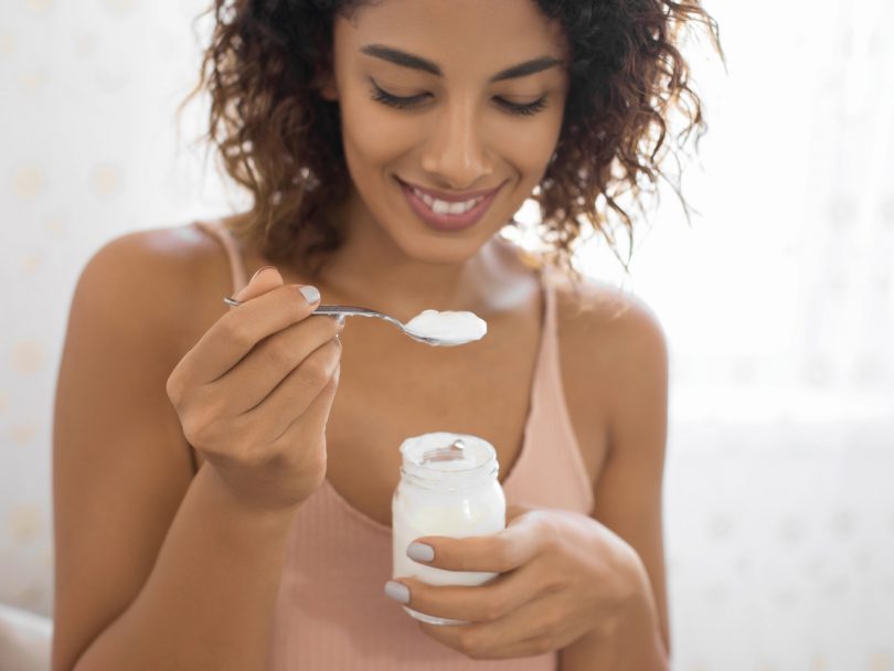 Woman Eating small container of Yogurt