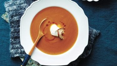 Slow cooker sweet potato soup with apples in a white bowl.