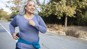 How to start running if you have never run before: A white-haired woman jogging on a trail