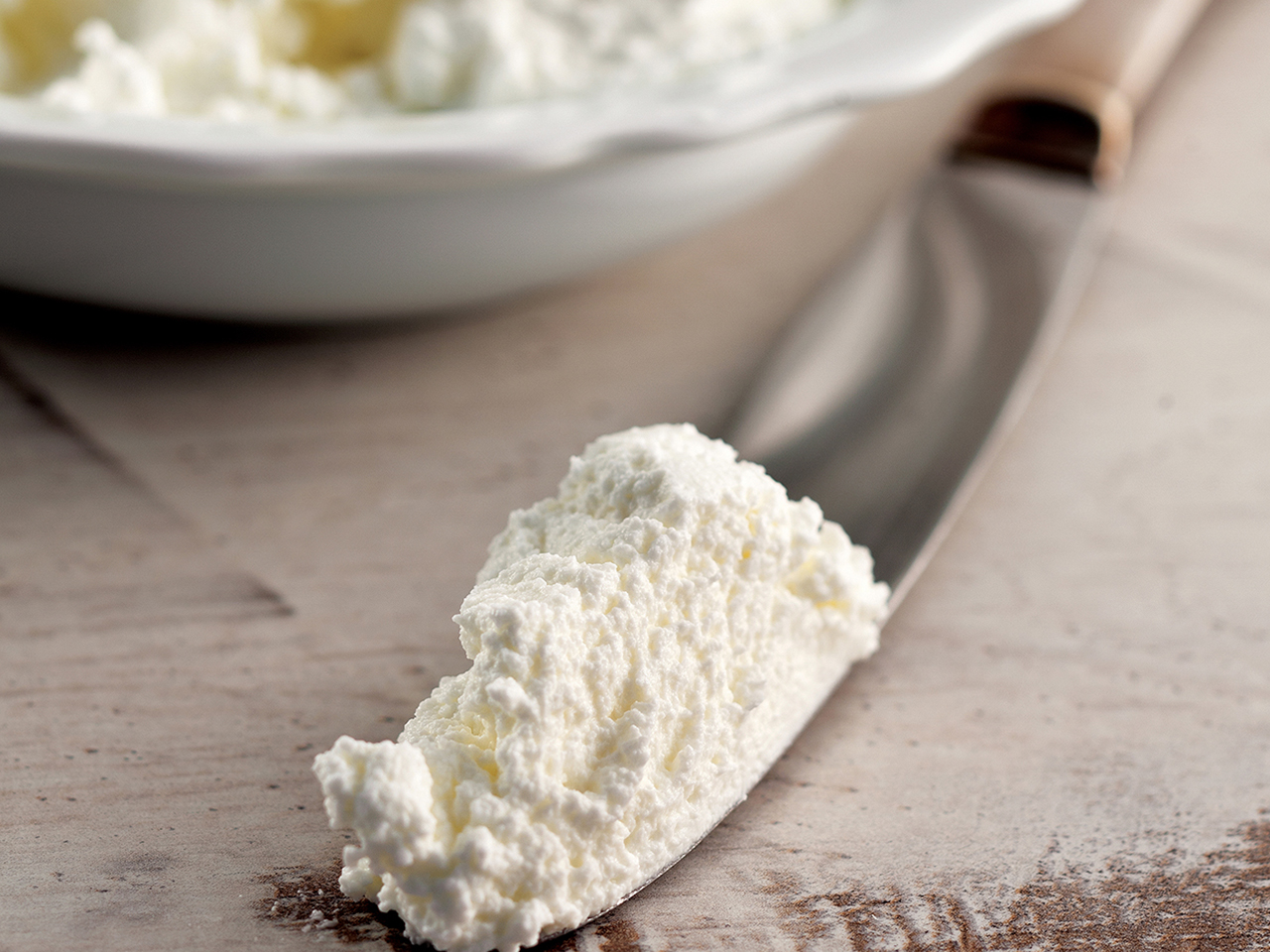 Ricotta in a bowl and on a knife
