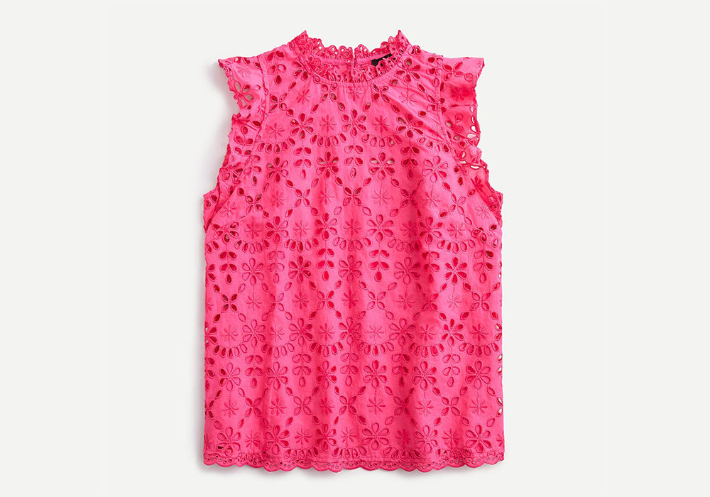A neon pink eyelet fabric top on a white background to illustrate the spring trends 2020.