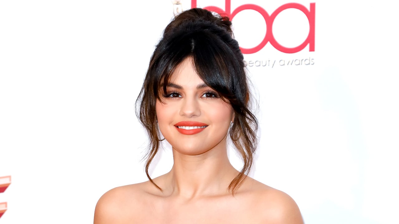 A photo of Selena Gomez with wispy side bangs to illustrate an article on how to trim your own bangs at home.
