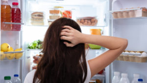 Woman Searching For Food In An Open Refrigerator