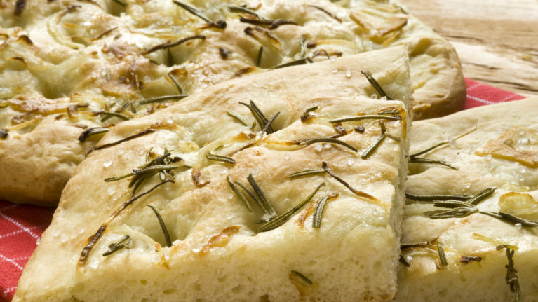 Slices of focaccia with rosemary, onions, garlic, olive oil and sea salt.