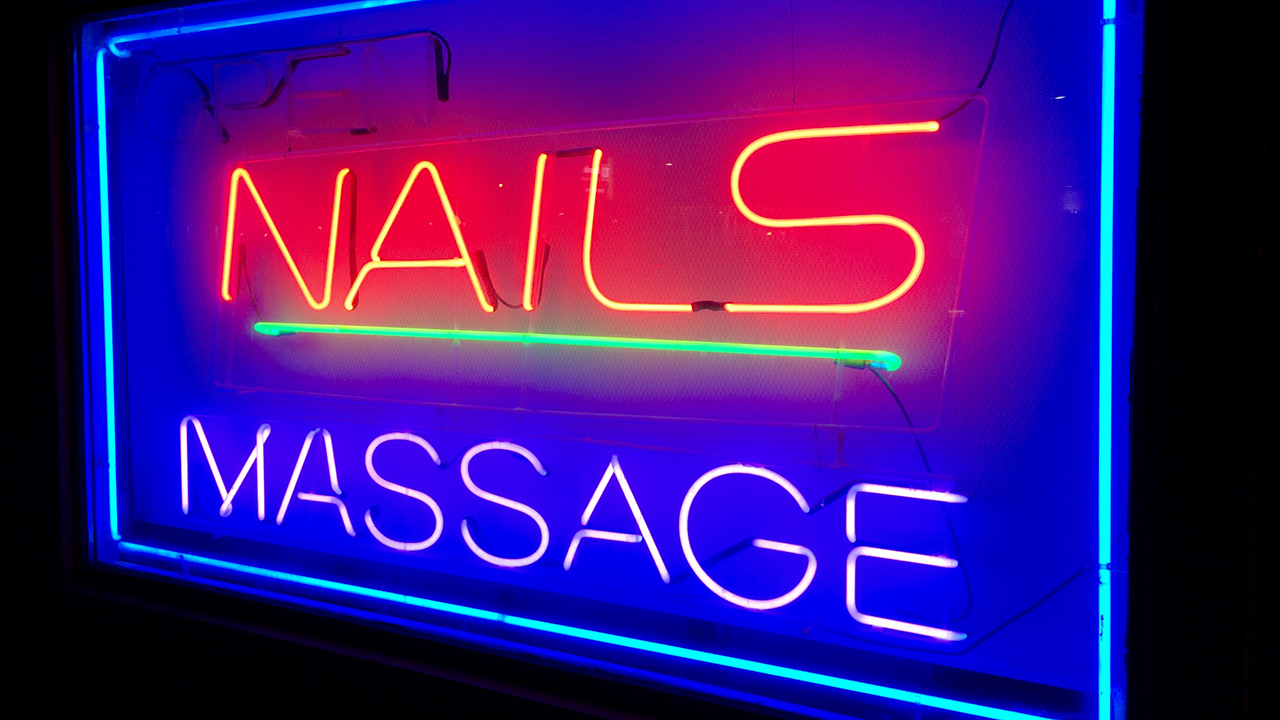 An image of a neon sign that says "Nails. Massage"