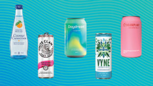 five different sparkling water cans on a green background