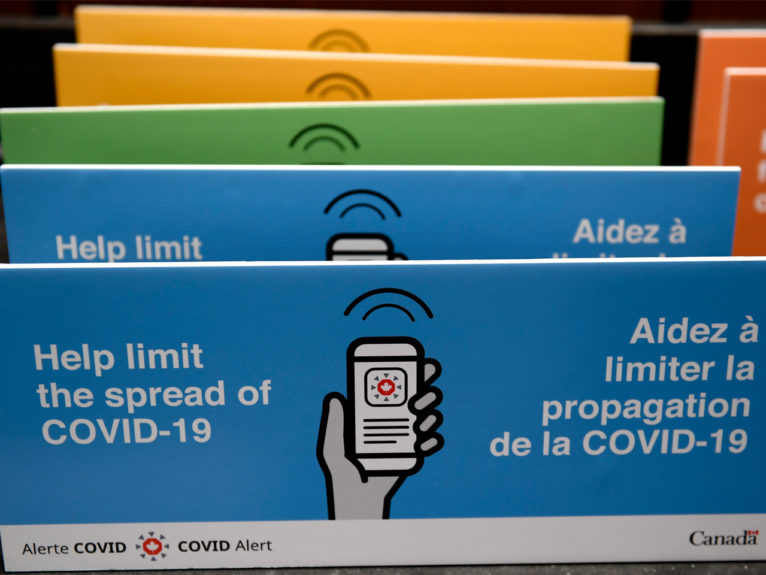 Podium placards promoting the COVID Alert app are seen on a table on Parliament Hill in Ottawa, on Friday, July 31, 2020