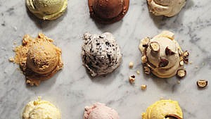 The difference between ice cream and gelato, explained. Image of nine ice cream scoops on marble table
