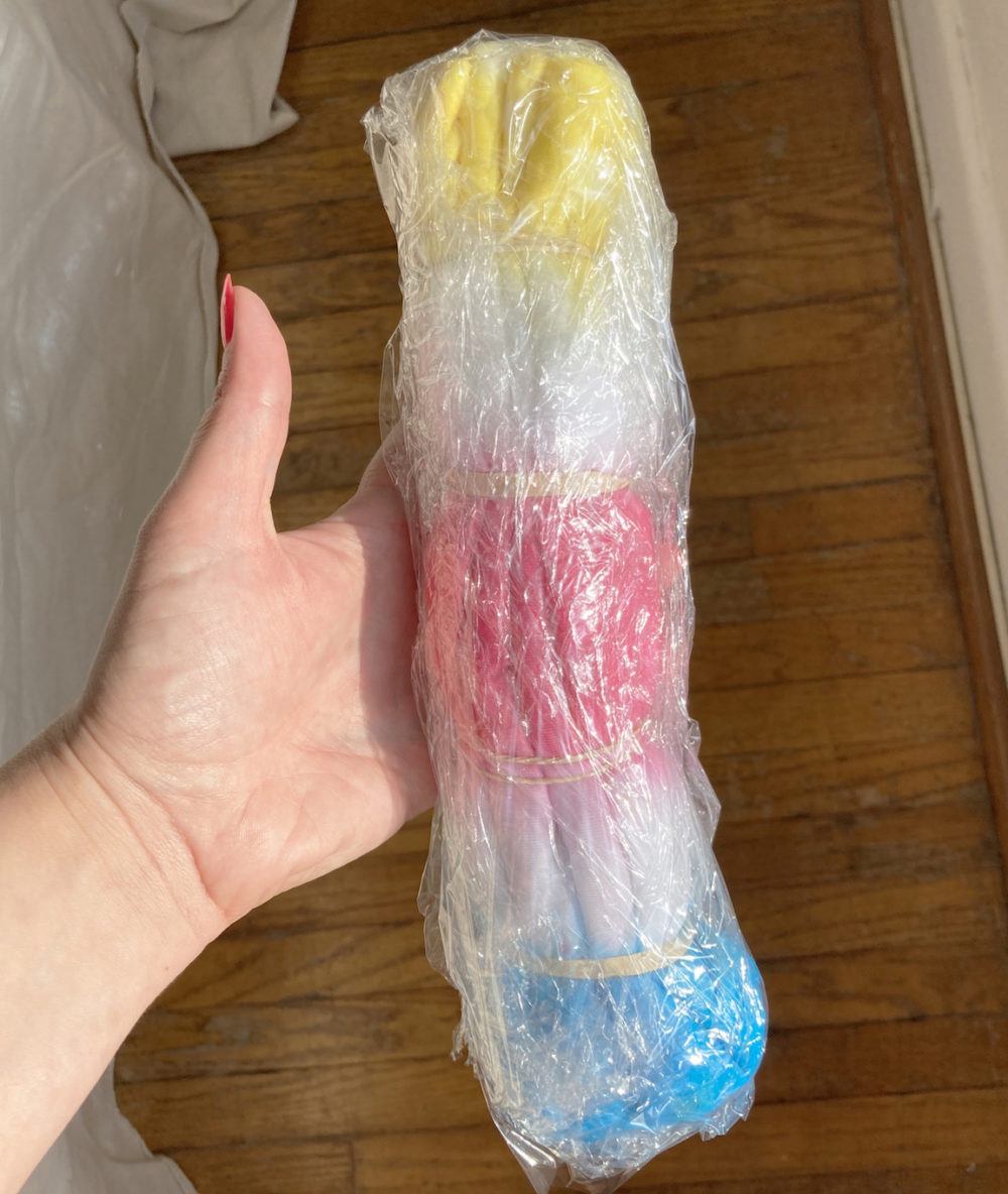 A tie-dyed t-shirt in plastic wrap ready to be microwaved