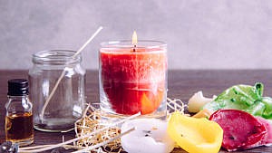 Photo of red candle and waxes of various colours.