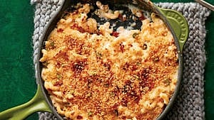 Baked pasta recipes: Swiss fondue mac & cheese in green cast-iron frying pan set on towel