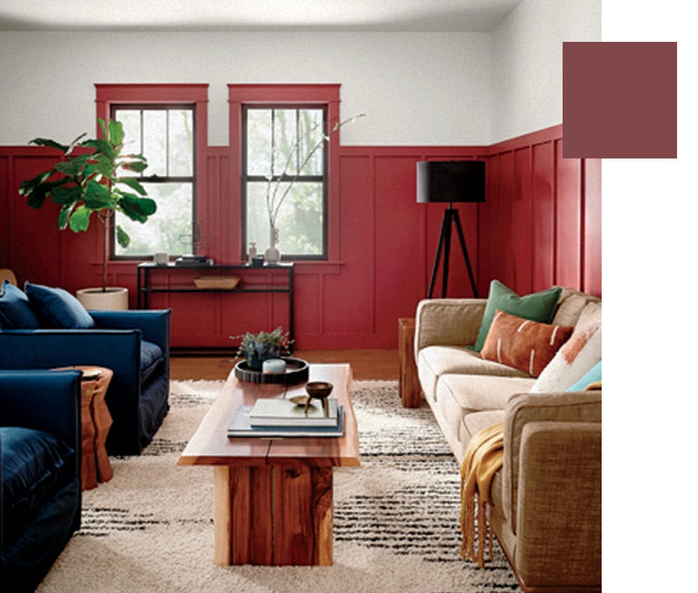 A living room with wainscotting and window trim painted a saturated magenta-meets-red.