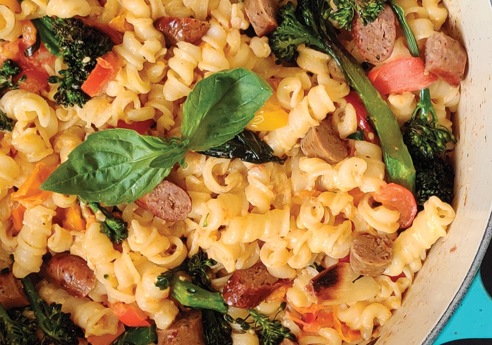 Close-up of creamy pasta recipe with cooked vegetables.