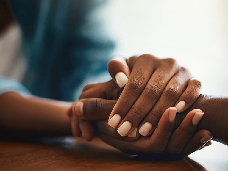 Two people hold hands across a table