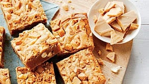Roasted white chocolate brown butter blondies on wooden cutting board