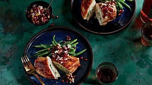 Stuffed chicken with pomegranate salsa and green beans on blue plates