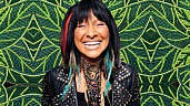 A photo of Buffy Sainte-Marie against a green beaded backdrop by Katie Longboat