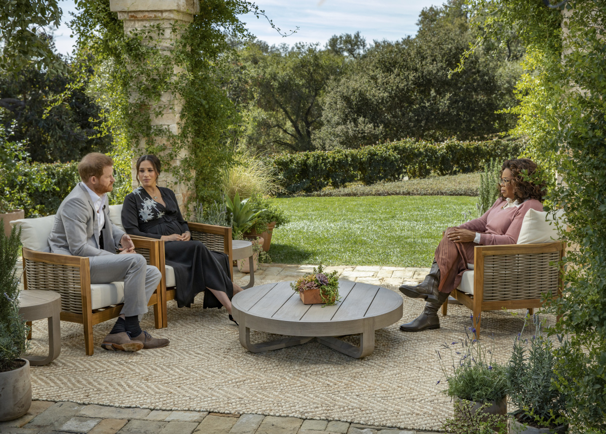 A wide shot of Prince Harry, Meghan Markle and Oprah speaking in a garden in the big CBS interview