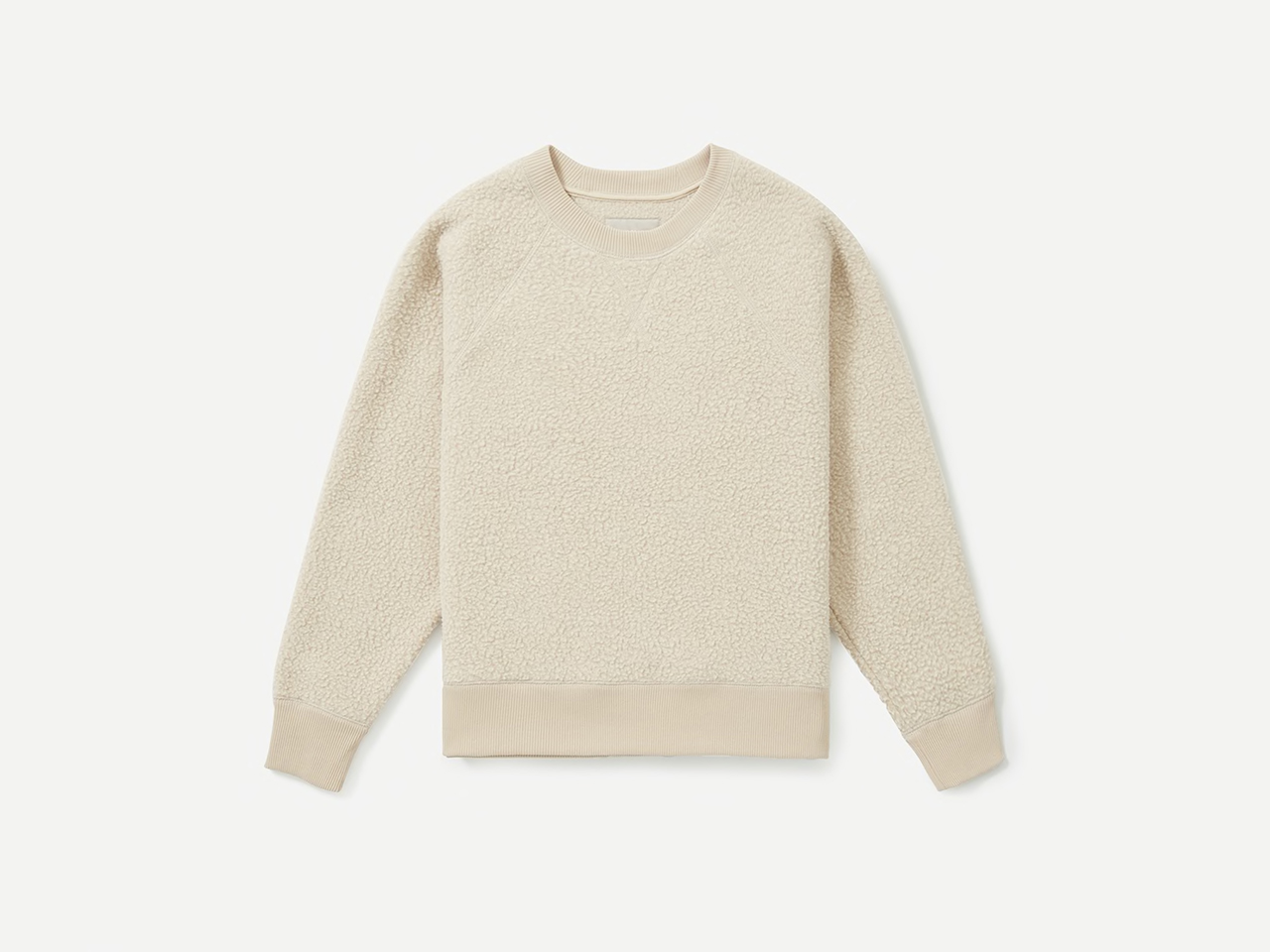 A cream fleece sweater made from recycled polyester on a light background.