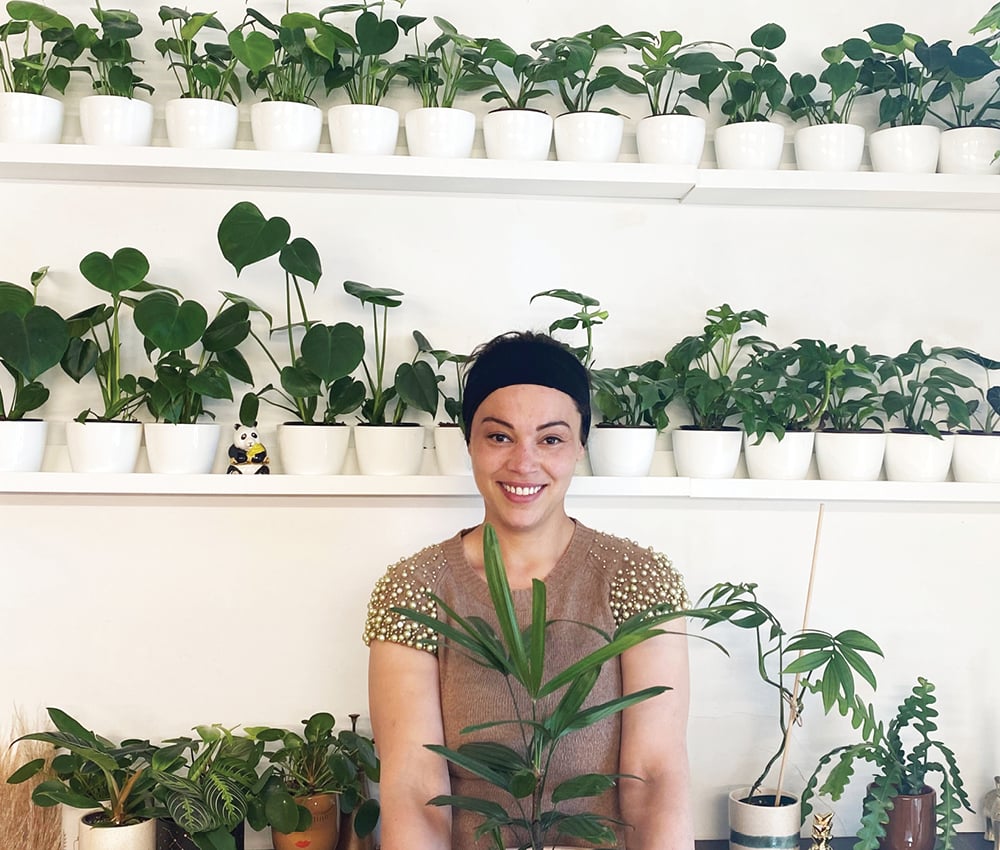 A woman photographed with her plants for an article on plant delivery in Canada.