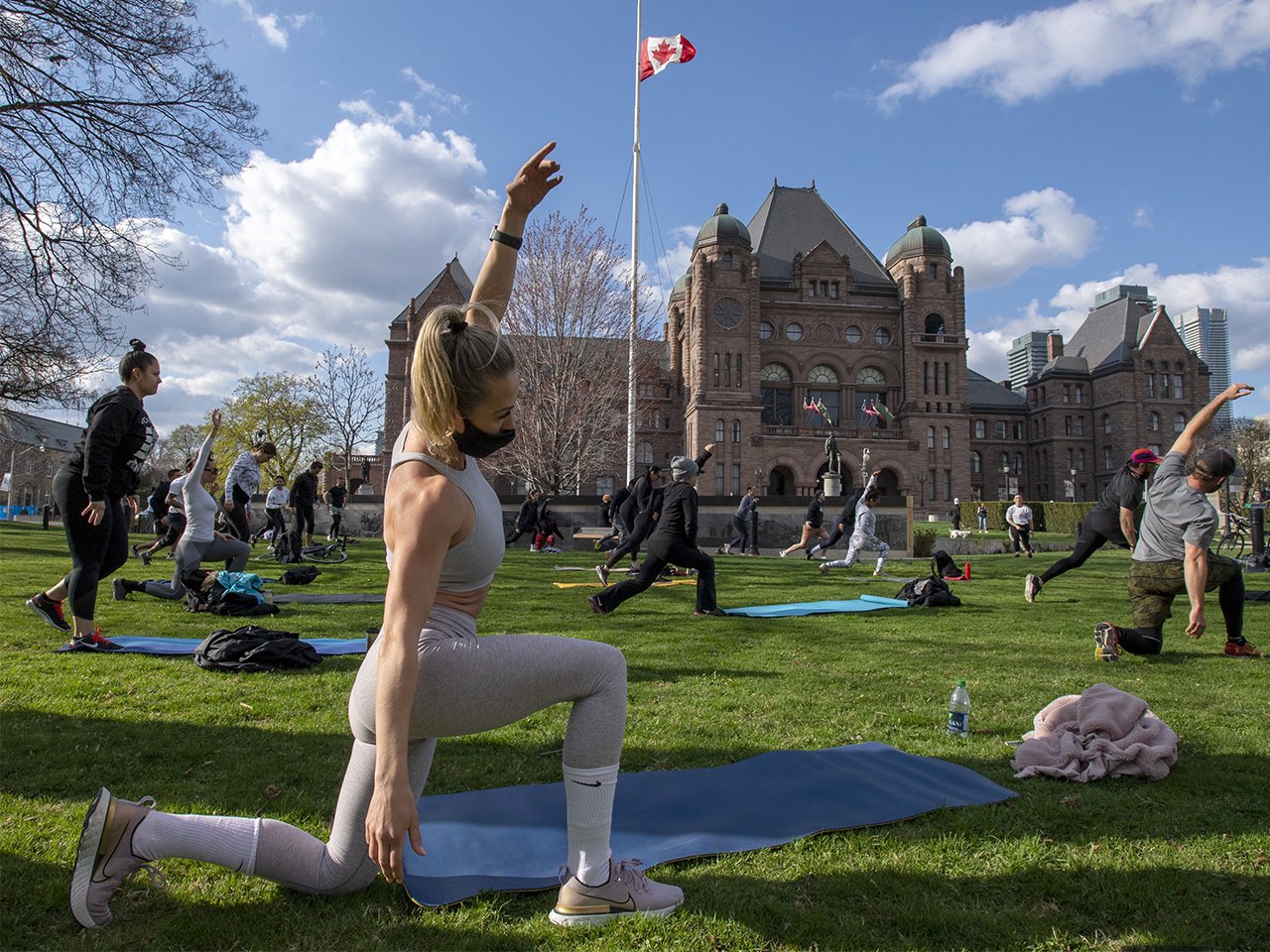 Members of the fitness community gather for a workout on the lawn of Queen's Park in Toronto on Wednesday, April 14, 2021.