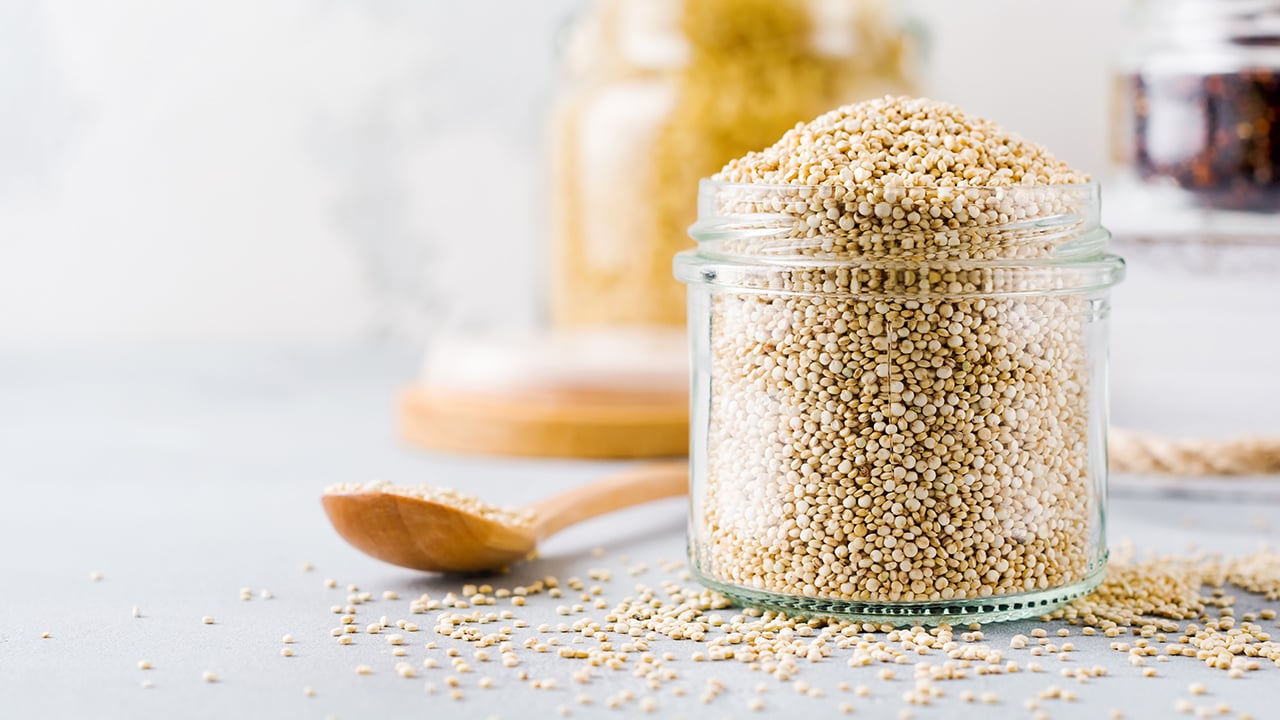 Raw quinoa grains in a jar to illustrate a piece on the nutritional value of intact whole grains