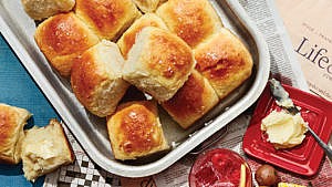 Fluffy potato rolls in a pan with butter and a cocktail on the side