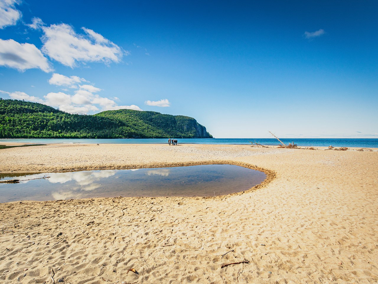 Landscape shot of a curvy beach, with water in its middle