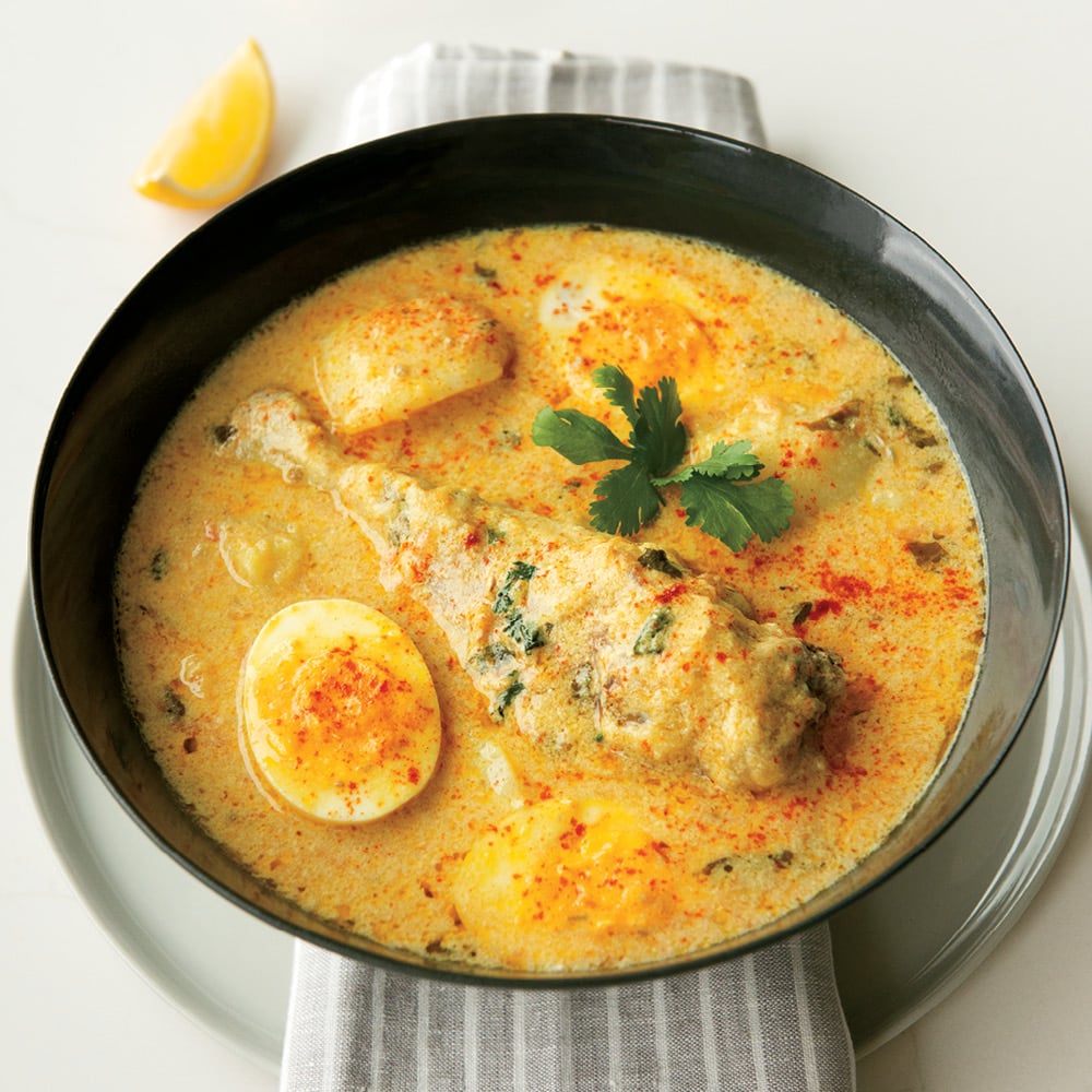 an image of chicken, potatoes and eggs in a coconut sauce (Kuku paka)