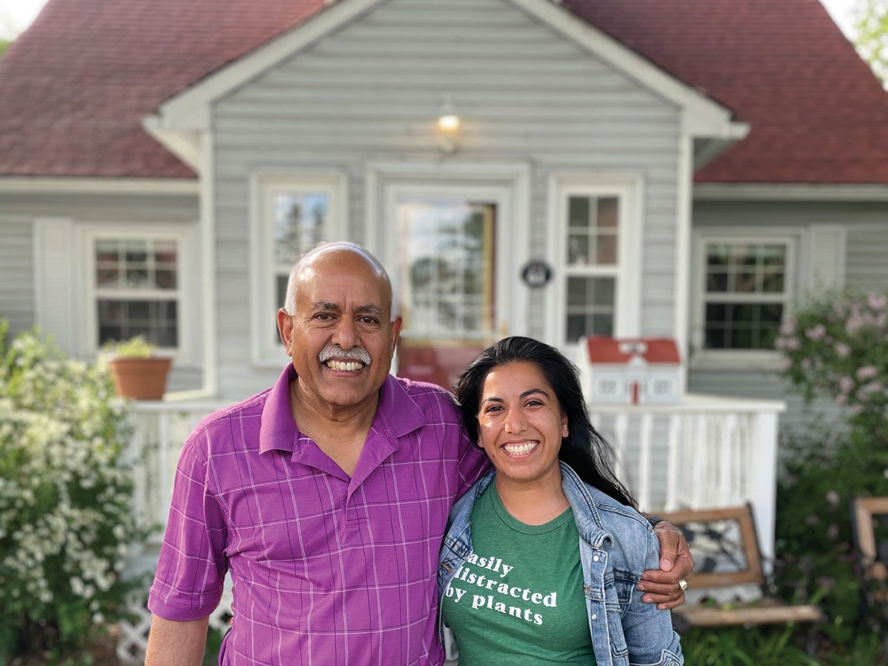 A photo of writer Ishani Nath and er father in front of a grey house