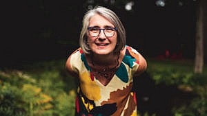 A portrait of crime writer Louise Penny leaning into the camera