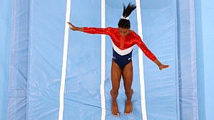 A photo of Simon Biles trying to regain her balance after a competition at the Tokyo Games.