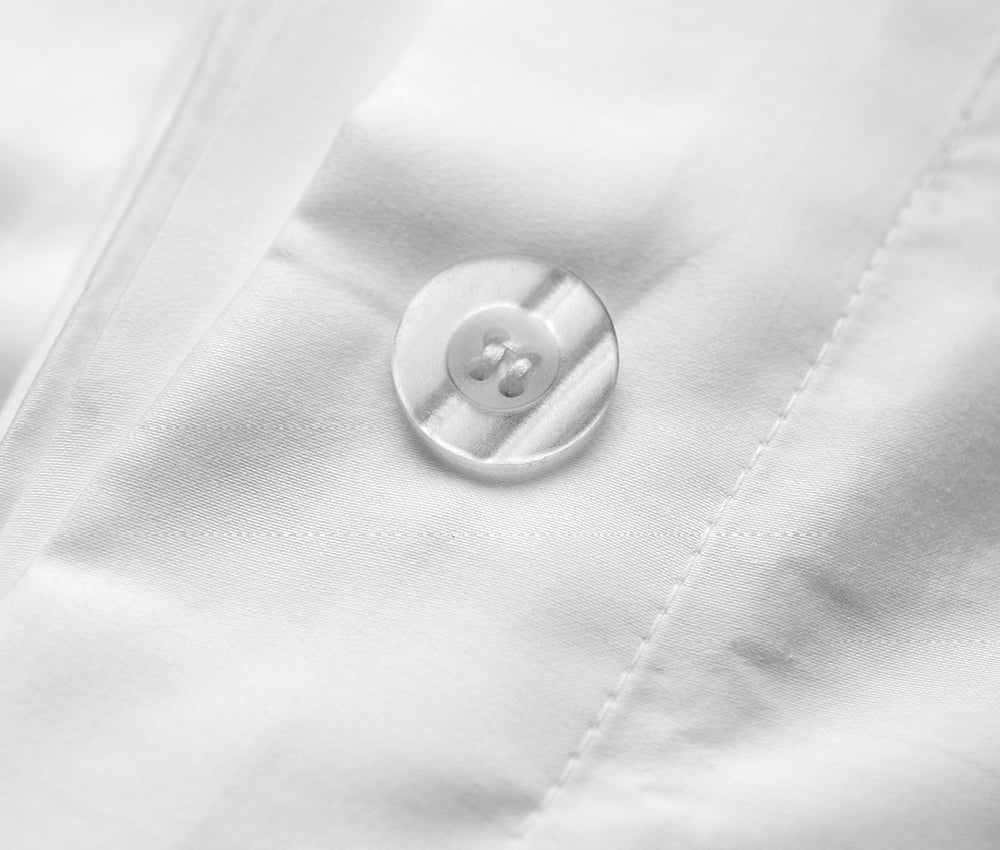 Close up of white KOTN bed sheet button