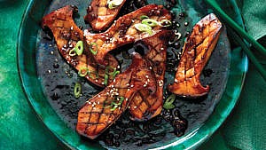 SOY-GLAZED KING MUSHROOMS on a green plate with green onions