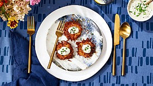 A plate of latkes on a blue dining table.