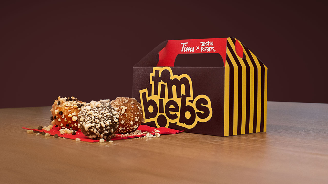 A box of Timbiebs from Tim Hortons with a irthday Cake Waffle, Sour Cream Chocolate Chip and Chocolate White Fudgeirthday Cake Waffle, Sour Cream Chocolate Chip and Chocolate White Fudge timbits in front