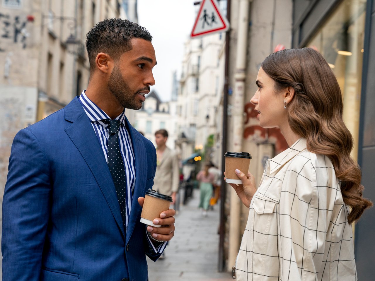 Photo of Emily (Lily Collins) and Alfie (Lucien Laviscount) standing outside chatting